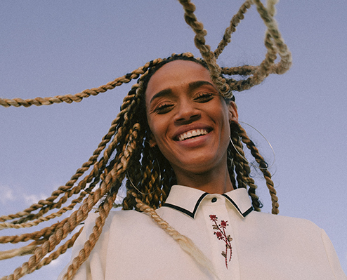 young woman smiling looking down on camera